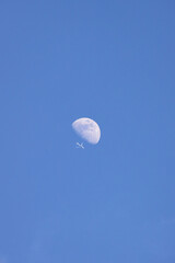A Jet Flying Under a Full Moon at Night, Color Image