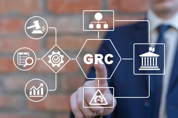 Businessman using virtual touchscreen presses abbreviation: GRC. Concept of GRC Governance Risk and...