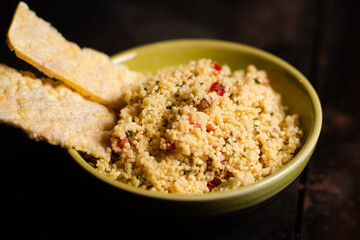 Rice bread and tomato and spice couscous salad on a dark background. Tabbouleh salad.