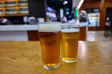 Fresh draught lager or IPA beer is glass served in indoor cafe close up, pint of beer