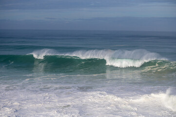 Magoito Beach during storm and high waves, beautiful sandy beach on Sintra coast, Lisbon district, Portugal, part of Sintra-Cascais Natural Park with natural points of interest