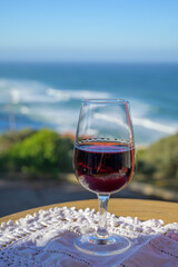 Tasting of tawny porto wine and   view on sandy beach and blue Atlantic ocean near Sintra in Lisbon area, Portugal