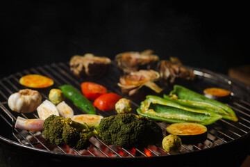 Green grilling. Various vegetables - artichokes, peppers, eggplants are grilled. Proper, vegan nutrition. Dark background. Red coals.