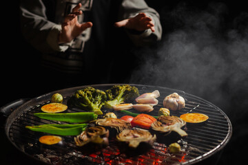 Green grilling. Various vegetables - artichokes, peppers, eggplants are grilled. Proper, vegan nutrition. Dark background. Red coals.