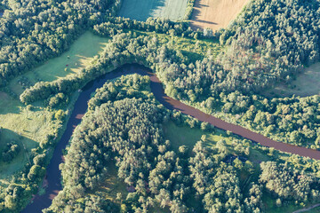 Obraz premium A bend of the river between Lithuanian forests, photographed while flying in a hot air balloon