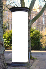 Empty advertising pillar in a city with free copy space, promotion mock up. Blank advertising panel...