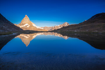 Fototapeta na wymiar Reflection of the Matterhorn on blue lake at sunrise, Swiss Alps, Zermatt