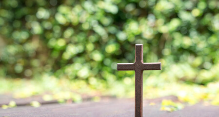 Cross crucifix  with green bokeh nature background. Good Friday or christianity concept.