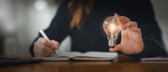 business woman hand holding light bulb. idea concept with innovation and inspiration