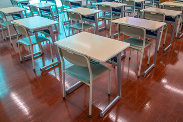 教室に並んだ生徒の机とイス。教室、学校イメージの背景素材