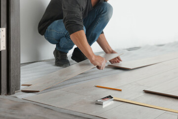 Worker installing new laminate flooring in room, closeup
