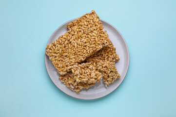 Puffed rice bars (kozinaki) on light blue background, top view