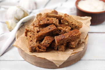 Delicious crispy rusks with sauce on white wooden table