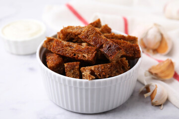 Crispy rusks with sauce on white marble table