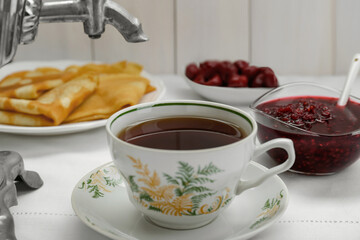 Cup of aromatic tea and treats on table, closeup