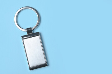 Metallic keychain on light blue background, top view. Space for text - obrazy, fototapety, plakaty