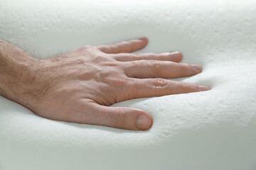 Man touching orthopedic memory foam pillow, closeup