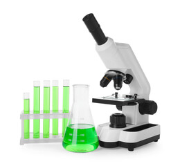 Laboratory glassware with green liquid and microscope isolated on white