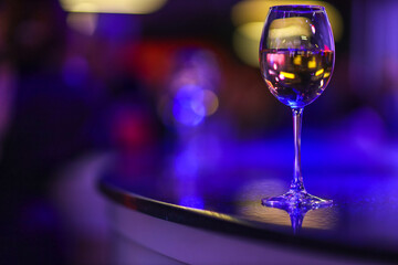 A glass of champagne on the background of lights from the garland. 