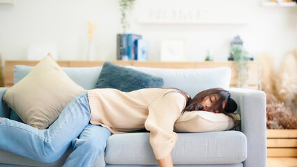Asian woman resting at home on couch, feeling exhausted after work, lacking energy, or overworked, too tired, and lacking motivation - obrazy, fototapety, plakaty