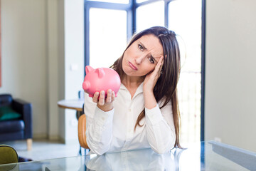 young adult pretty woman with a piggy bank. money and savings concept