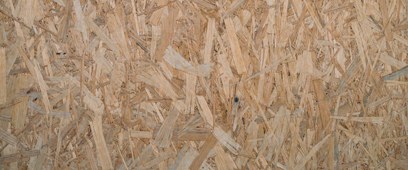 Minimal backdrop with pattern of natural pressed sawdust close-up. Minimalist background with sheet of plywood with compressed sawdust fragment. Wooden texture template close up.