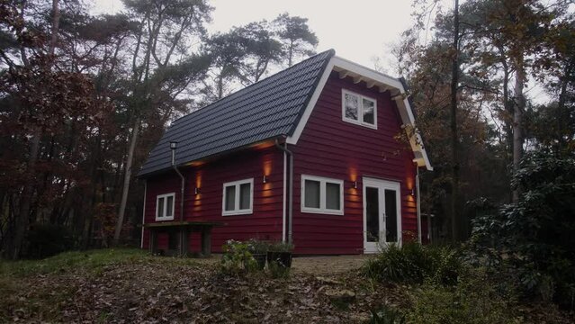 Red wooden house in the forest during winter