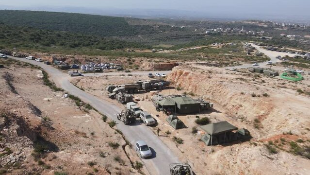 Israel Army soldiers on Humvee vehicles driving through training ground country road, Israeli army camping area, Aerial shot