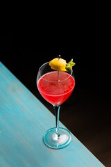 Refreshing tropical boozy cocktail with lemon juice on black background