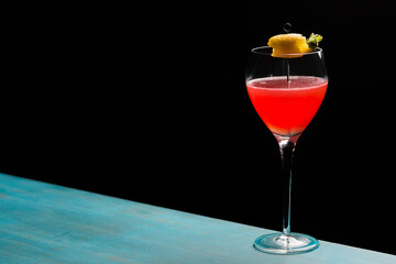 Refreshing tropical boozy cocktail with lemon juice on black background