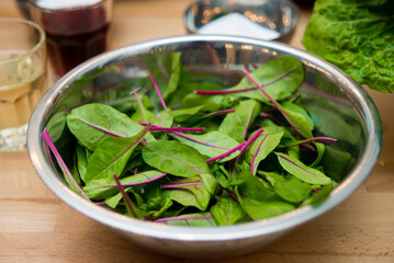 Green salad in a bowl on a wooden table, close-up