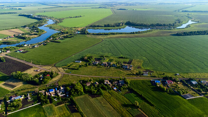 view from a height to the green fields of crops, the pond for irrigation, the sun's glare and tinting,