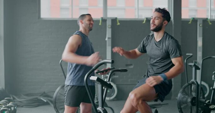 Personal trainer, high five and exercise bike with a man athlete in the gym for a cardio or endurance workout. Coach, fitness and elliptical machine with a male training for cardiovascular health