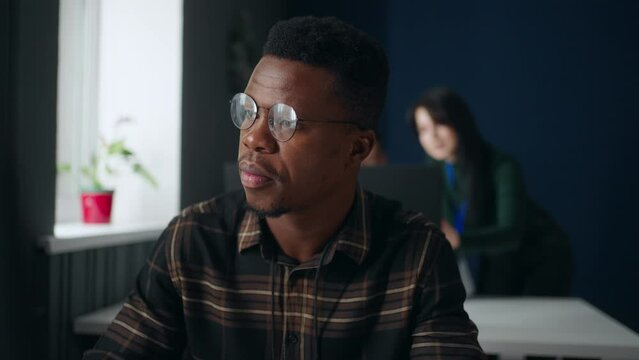 african american guy working with computer in office of software development company, portrait