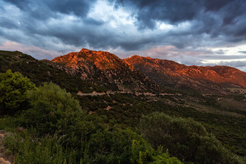 Rocky Mountains on the Sea Coast of Sardinia, Italy. Dramatic Sunset Sky. Nature Background.