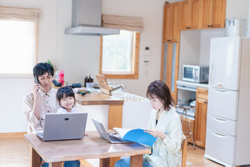 テレワークをする夫婦と子供