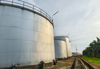 Oil storage tank In industrial areas. Crude oil storage plant For export. Palm oil factories in Asia. The atmosphere at sunset. With in the industrial plant. Zone tank storage industry. Power station  © Яe Life Яe World