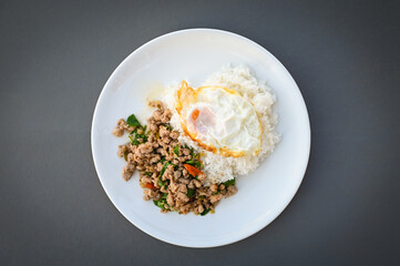 holy basil minced pork, Stir fried Thai basil with minced pork and a fried egg on white plate - top view