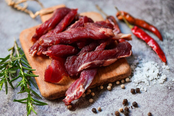 beef jerky with herbs and spices - dried beef on wooden plate, raw dried meat for cooking, dry meat beef in Thailand food
