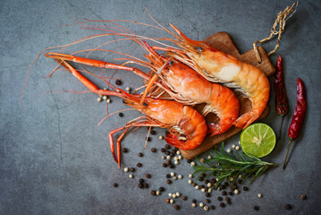 shrimp grilled delicious seasoning spices on black plate appetizing cooked shrimps baked prawns rosemary lemon lime pepper, seafood shelfish - top view