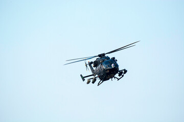 Combat helicopter is flying against isolated blue sky. combat helicopter attack enemy.