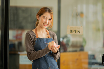 A young coffee shop employee is opening a shop for service.