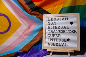 LGBTQIA description frame on Rainbow LGBTQIA flag made from silk material. LESBIAN, GAY, BISEXUAL,...