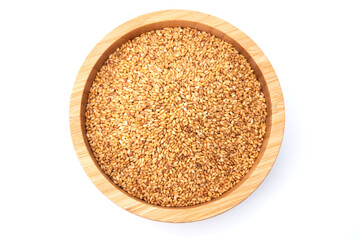 Top view of golden sesame seeds in wooden bowl isolated on white background