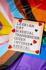 LGBTQIA description frame on Rainbow LGBTQIA flag made from silk material. LESBIAN, GAY, BISEXUAL,...