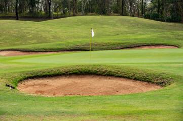 Fototapeta premium Scenery view of bunker in golf course. A bunker is positioned in the golf hole to guard the desired position in the landing area or green.