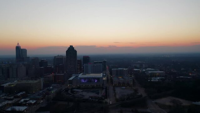 Aerial truck shot of sunset over Raleigh North Carolina skyline. Cinematic drone shot of urban metropolis at night.