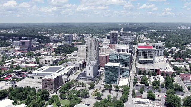 Aerial orbit of Raleigh skyline in NC. American city with drone speed ramp shot on beautiful sunny day.