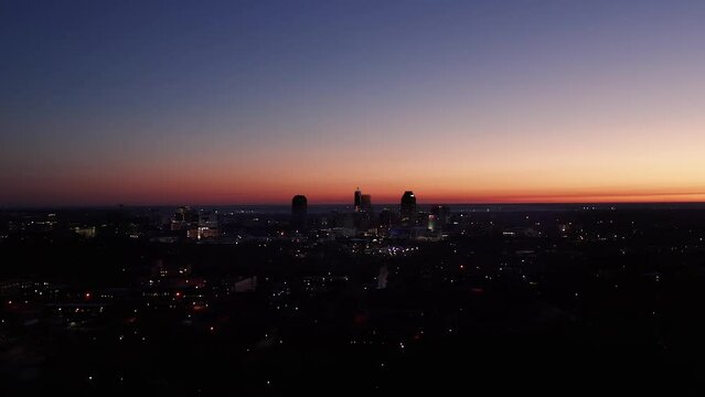 Aerial shot of silhouette of Raleigh NC. American city skyline with orange sunrise.