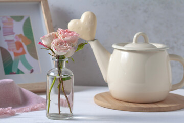 Postcard with the image of a pink rose in a glass vase